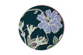 A round decorative plate or tray featuring a dark teal background with a large lavender-blue flower and green leaves outlined in cream, shown on a plain white background.